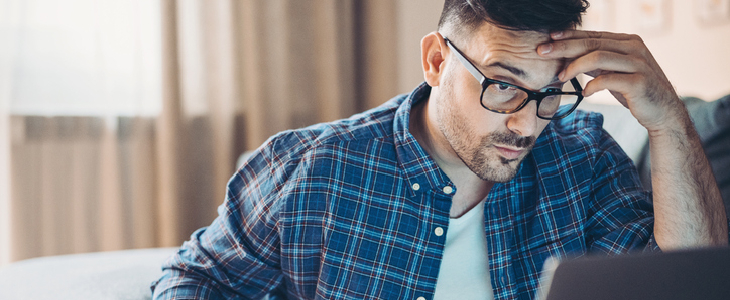 stressed man looking at his computer screen