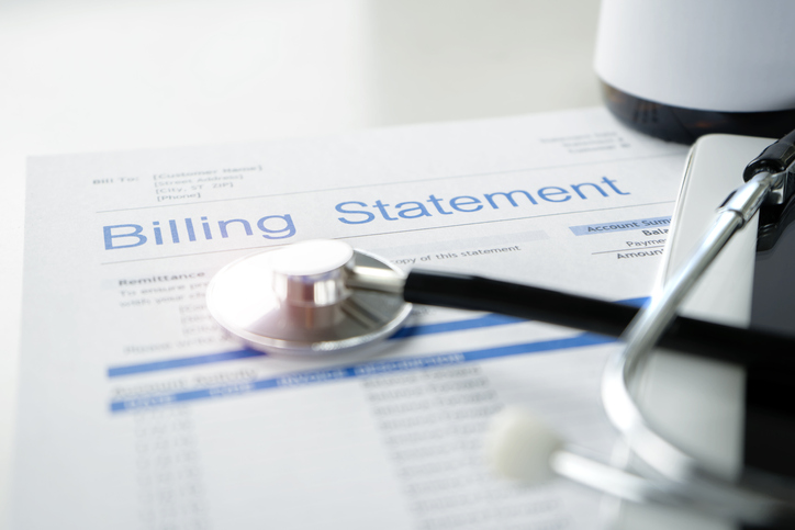 Health care billing statement with stethoscope, bottle of medicine for doctor's work in medical center stone background.